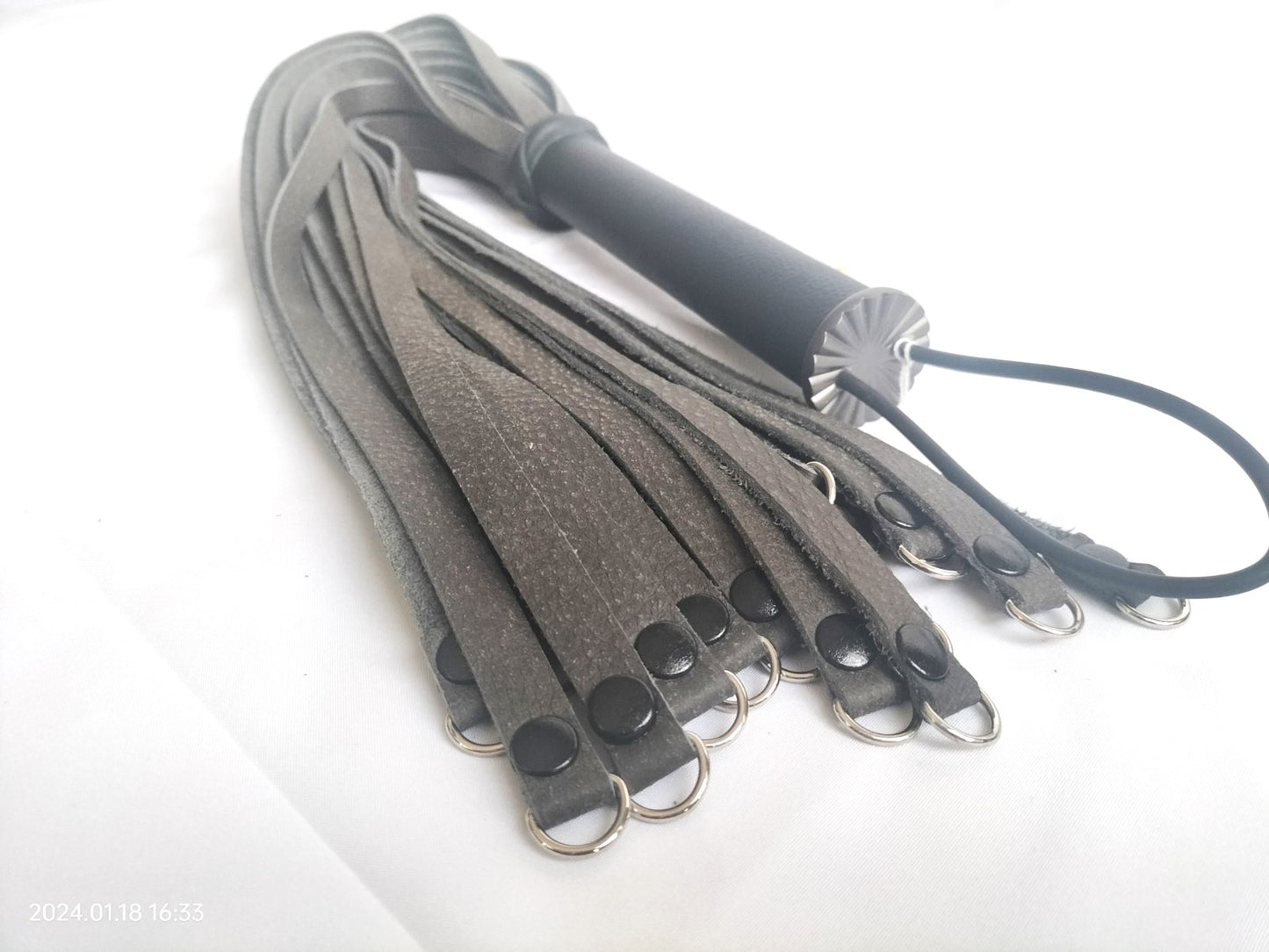 Anthracite leather flogger with black leather handle and weighted with double rivets and D-rings