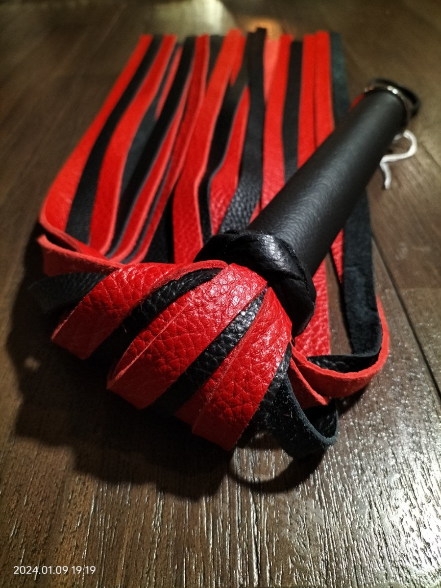 Rood/zwart lederen flogger met zwart leer handvat