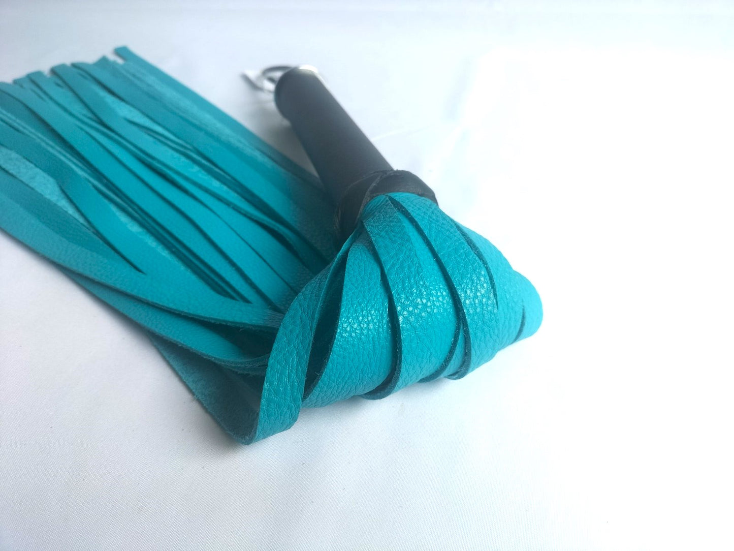 Turquoise lederen flogger met zwart leer handvat