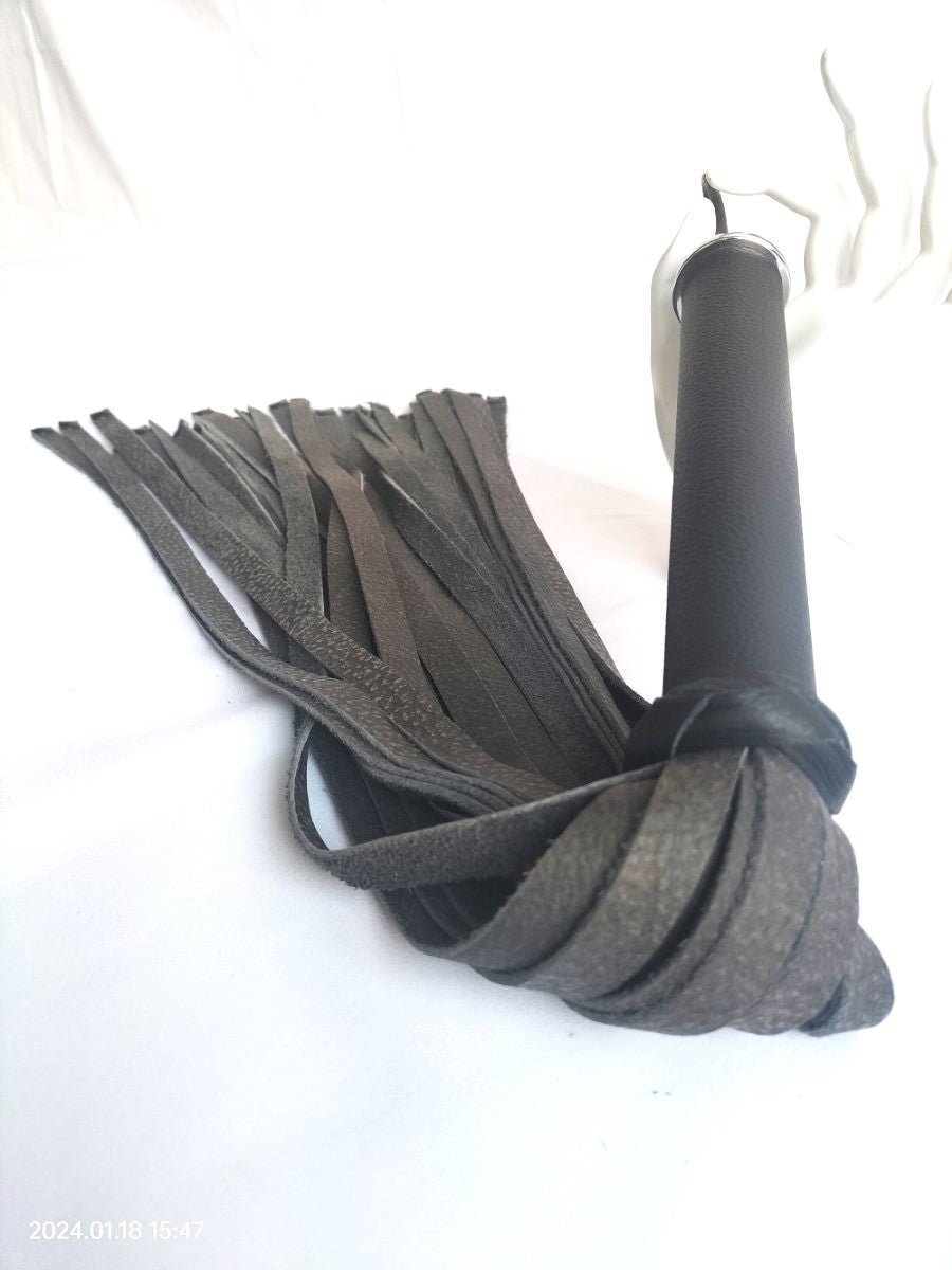 Antraciet lederen flogger met zwart leer handvat en zwarte dubbele holnieten - SM - speeltjes