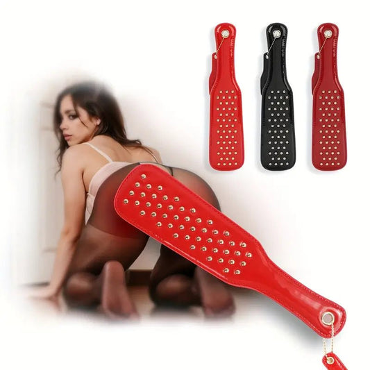 deze-glanzend-rode-paddel-is-een-leuke-instapper-voor-je-bdsm-spel-of-een-leuke-bdsm-toy-aanvulling-op-je-reeds-bestaande-assortiment-met-zijn-tientallen-vergulden-studskomt-hij-net-weer-iets-anders-aan-dan-je-andere-paddels-1