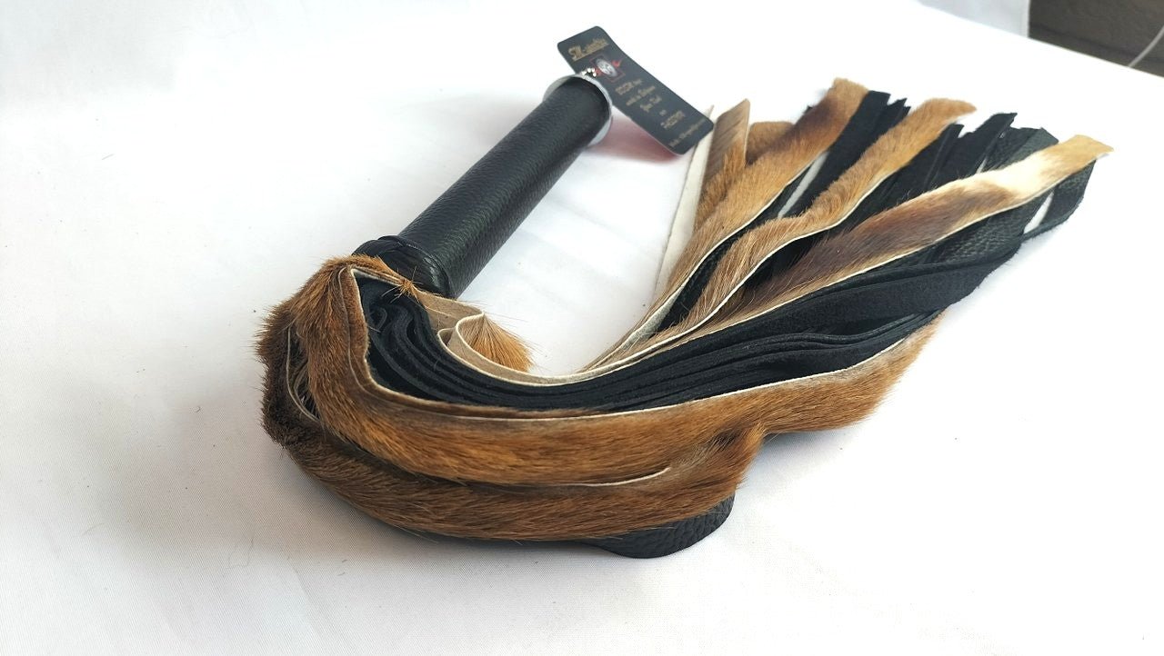 met-deze-prachtige-flogger-gemaakt-van-beige-springbok-en-zwart-leer-haal-je-jezelf-een-uniek-stuk-in-huis-bij-elke-slag-of-streling-voelt-hij-dankzij-zijn-combinatie-tussen-de-vacht-en-het-leer-anders-aan-2