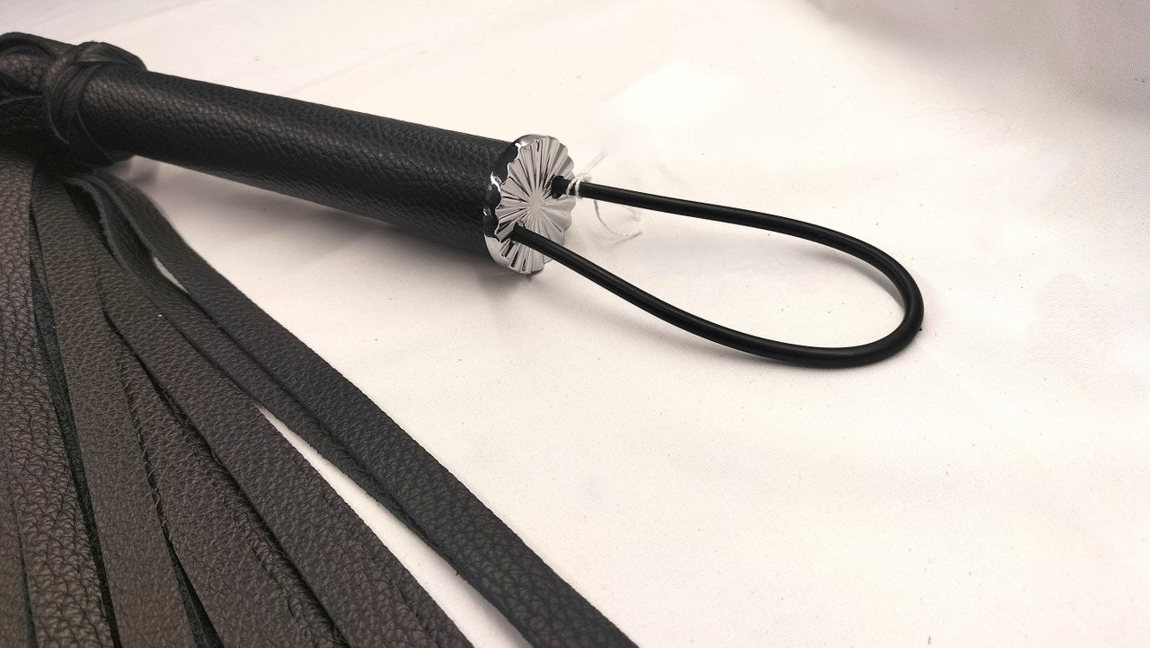 Zwart lederen zweep met D-ringen - BDSM accessoire close-up